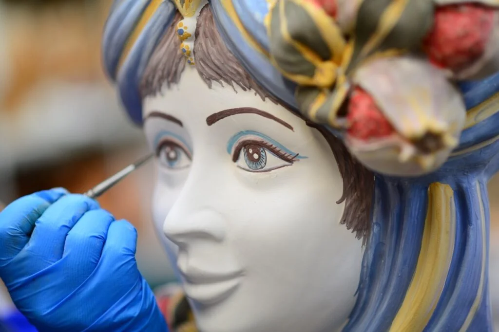 Caltagirone pieces at different stages of production, from raw clay to glazed and painted