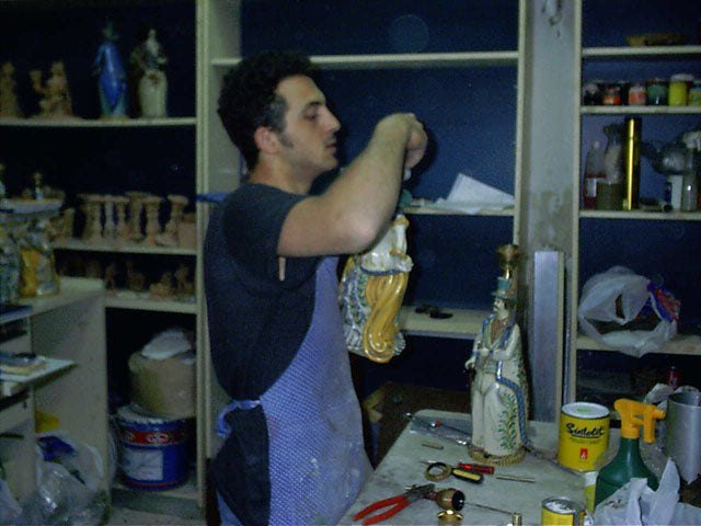 Giuseppe Intonato finishing a painted figure in the workshop