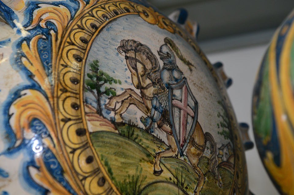 Detail of a maiolica vase hand-painted with a knight on horseback inside a Baroque frame