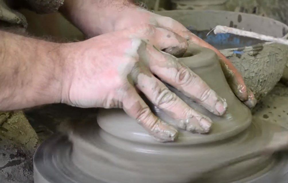 Hands shaping clay on the potter's wheel